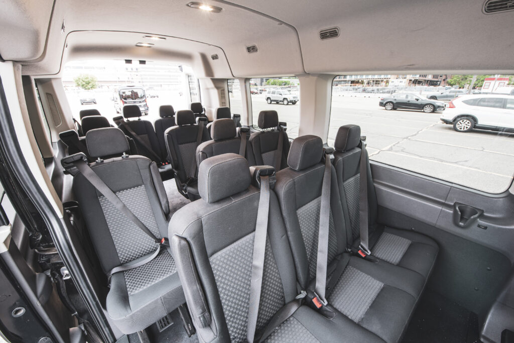 The interior of a Ford Transit 15 passenger van with all seat rows.