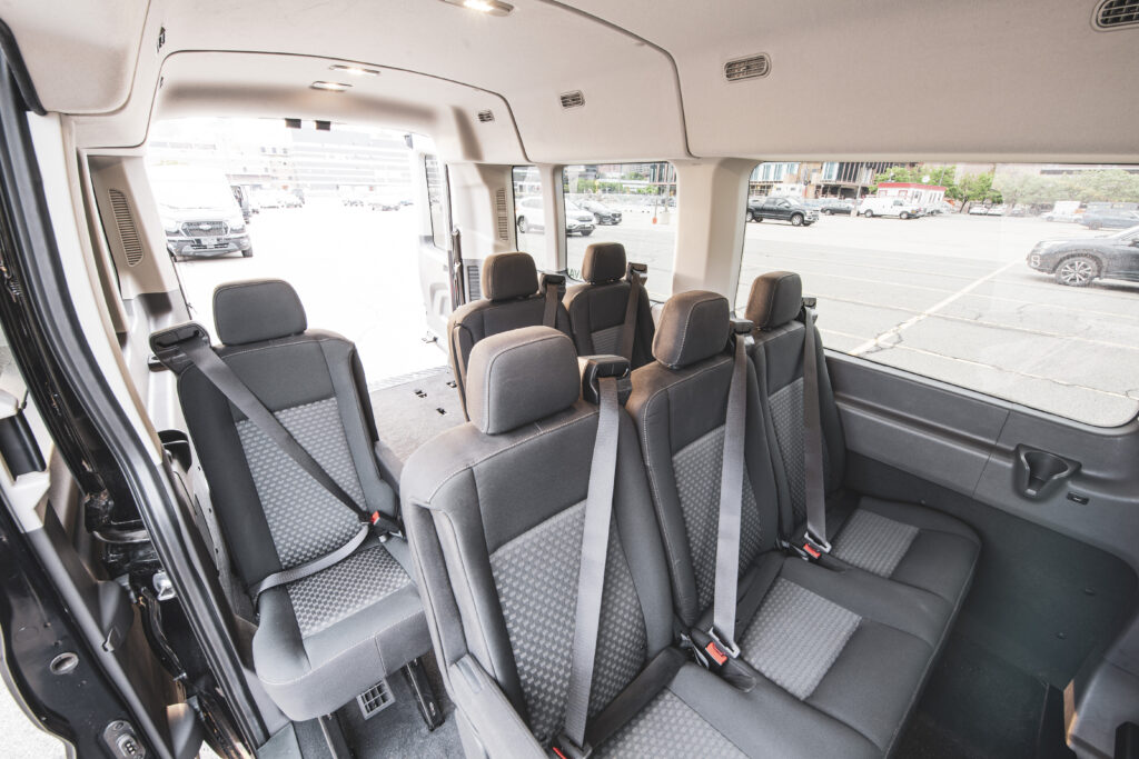 The interior of a Ford Transit 15 passenger van with all seat rows.