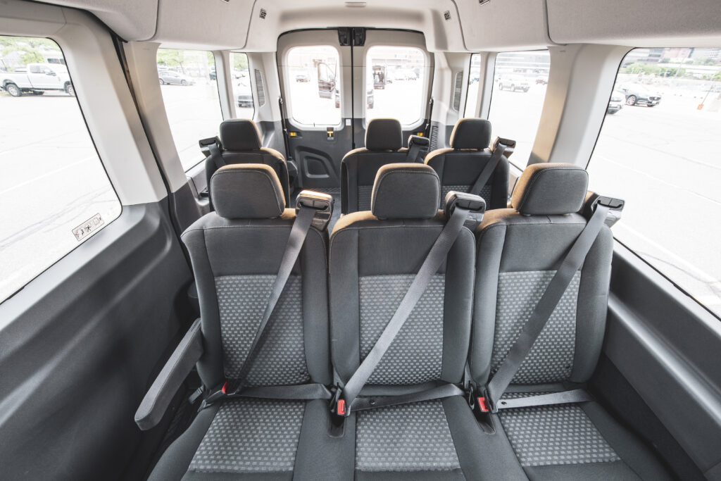 The interior of a Ford Transit 15 passenger van with all seat rows.