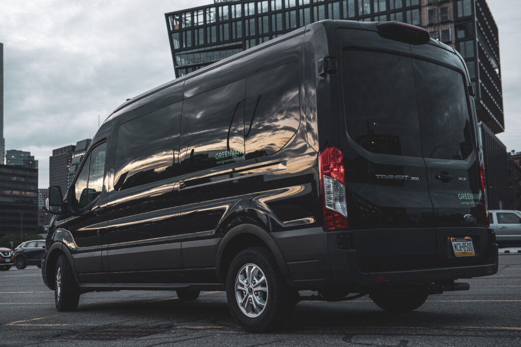 a black For Transit van in front of a cityscape