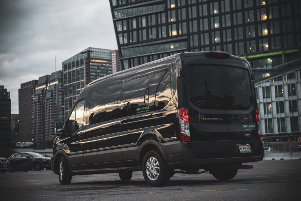 A Greenvans passenger van in front of a city skyline.