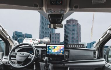 Interior dashboard of a Ford Transit passenger van with the Boston skyline through the windshield