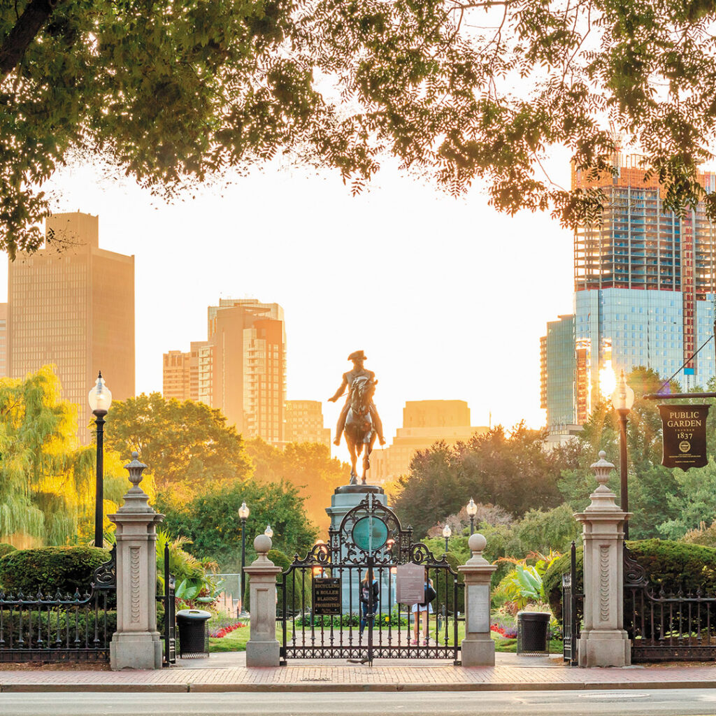 A statue at sunset on the Freedom Trail in Boston with skyline in the background