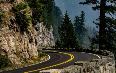 A winding road through a U.S. National Park with mountains and pine trees.