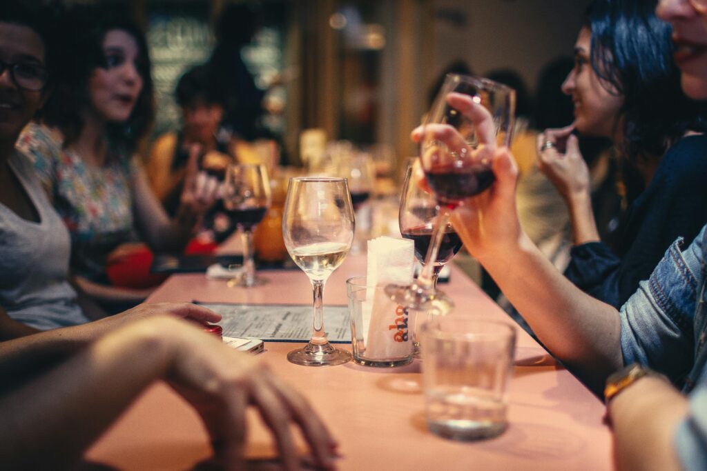 group of people drinking wine at a long table