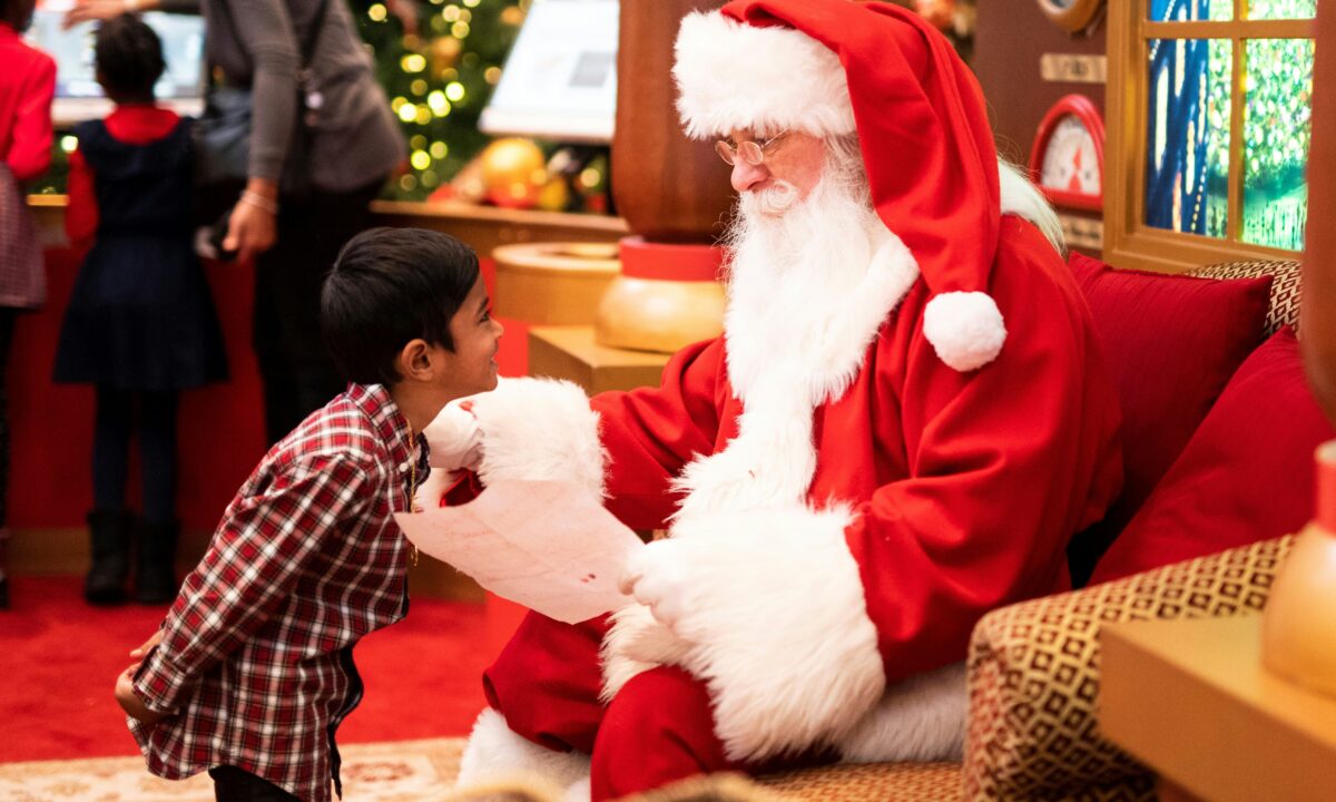 A young boy giving Santa a Christmas letter, Photo by __ drz __ on Unsplash