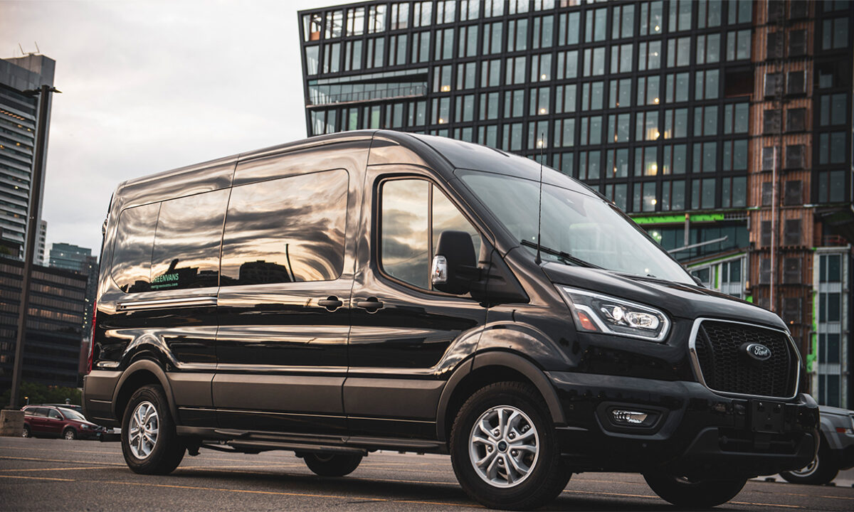 Greenvans black Ford Transit passenger van in front of an office building