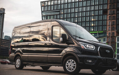 Greenvans black Ford Transit passenger van in front of an office building